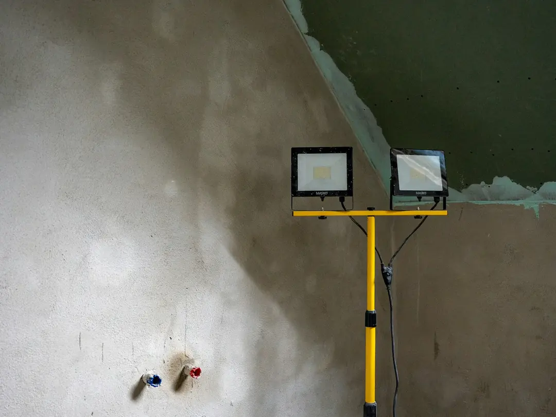 Ambiente em obra com iluminação de trabalho e parede em acabamento